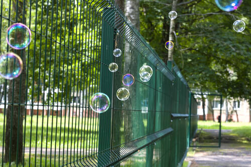Soap bubbles against background green trees