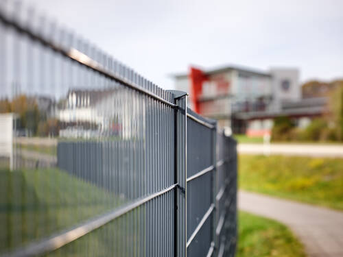 Gitterzaun als Grundstücksgrenze eines Industriegebietes